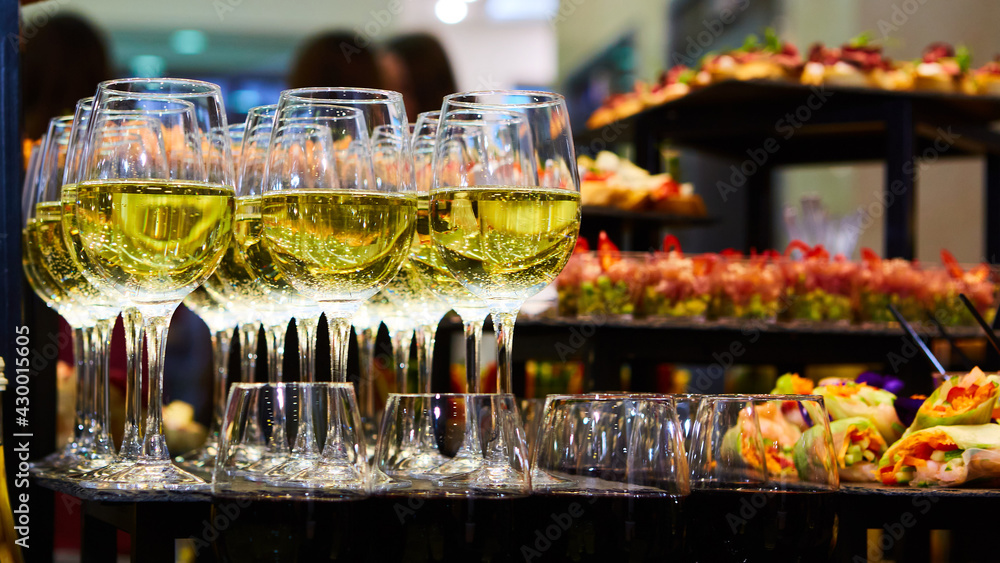Glasses of white wine are on the table, ready to serve. Glasses of white wine are on the table, ready to serve.
