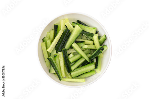 Sliced cucumber in a plate on a white background. Fresh cucumber sliced into pieces close-up.