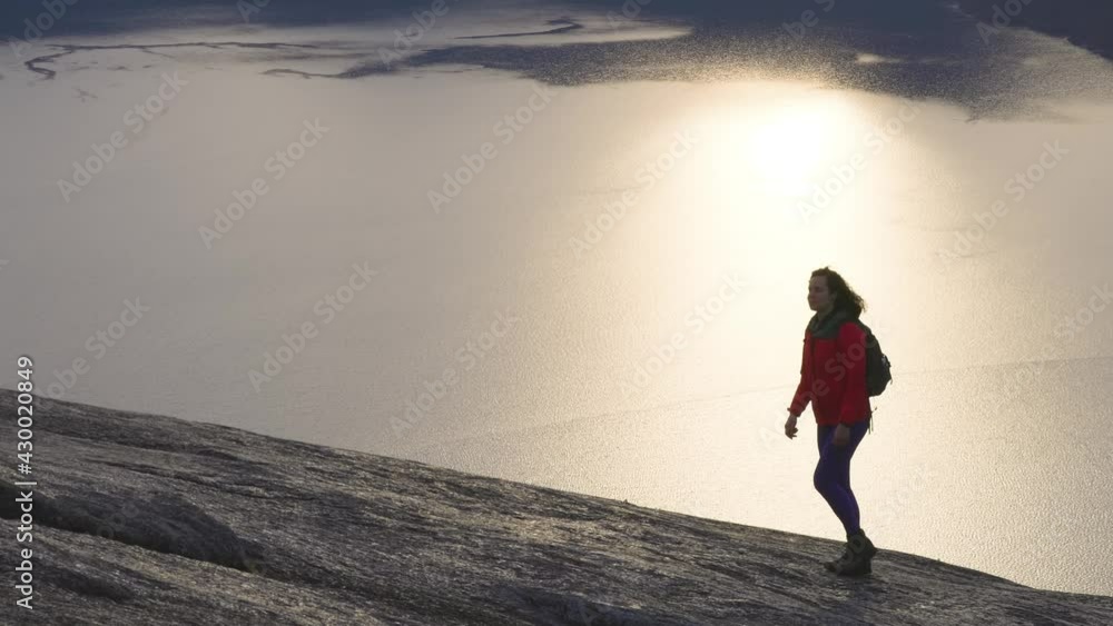 Adventurous Woman Hiking on top of a Peak, Chief Mountain, during winter sunset. Located in Squamish, North of Vancouver, British Columbia, Canada. Slow Motion Adventurous Woman Hiking on top of a Peak, Chief Mountain, during winter sunset. Located in Squamish, North of Vancouver, British Columbia, Canada. Slow Motion