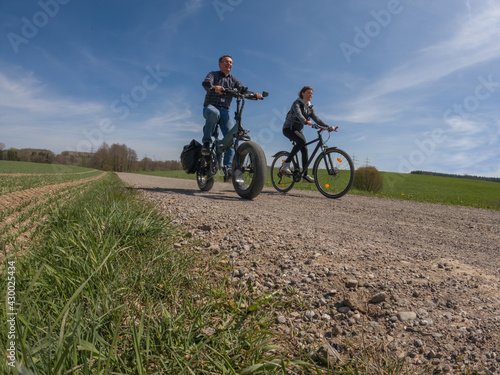 Young couple making bike trip with modern electric fat bike and trekking bike