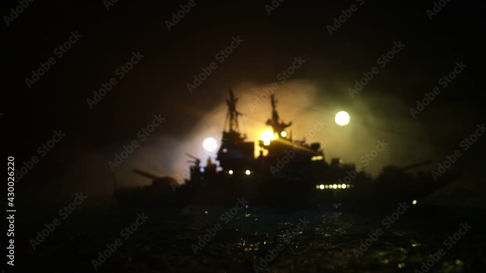 War concept. Night battle scene at sea. Dramatic toned clouds effect. Silhouette of the battle ship in night. Miniature creative table decoration. Selective focus War concept. Night battle scene at sea. Dramatic toned clouds effect. Silhouette of the battle ship in night. Miniature creative table decoration. Selective focus