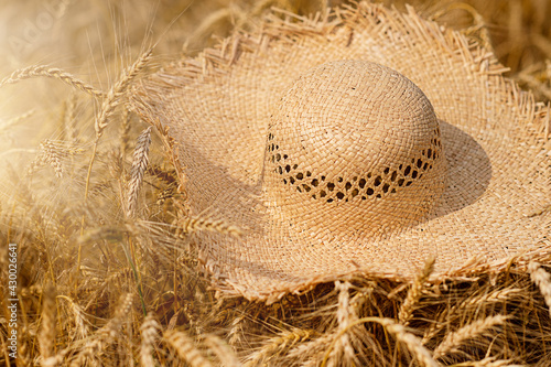 A straw hat lies on the ears of wheat