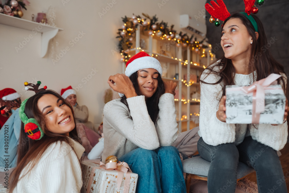 Fototapeta premium Multiethnic group of friends in Santa hats with gifts in hands.