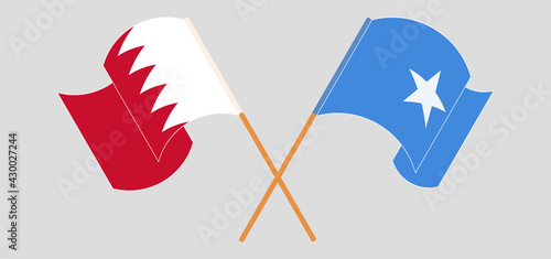 Crossed and waving flags of Bahrain and Somalia