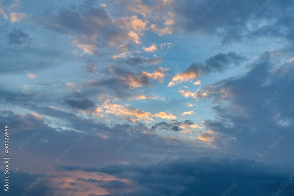 Fototapeta premium The sky at sunset. Cumulus clouds lit by the rays of the setting sun.