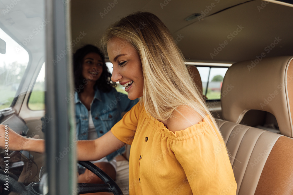 Side view of a blond woman on driver seat in a camper van