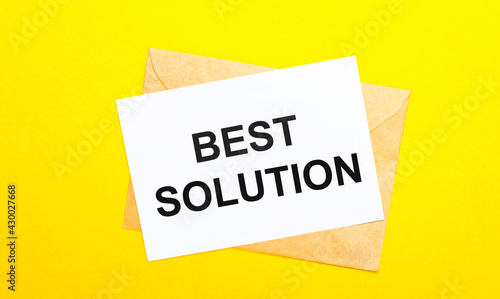 On a yellow background, an envelope and a card with the text BEST SOLUTION. View from above