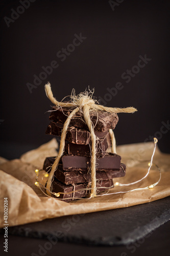 Wallpaper Mural Stacked chocolate bars. Dark chocolate on parchment paper tied with twine on black. Dark chocolate with garland. Torontodigital.ca