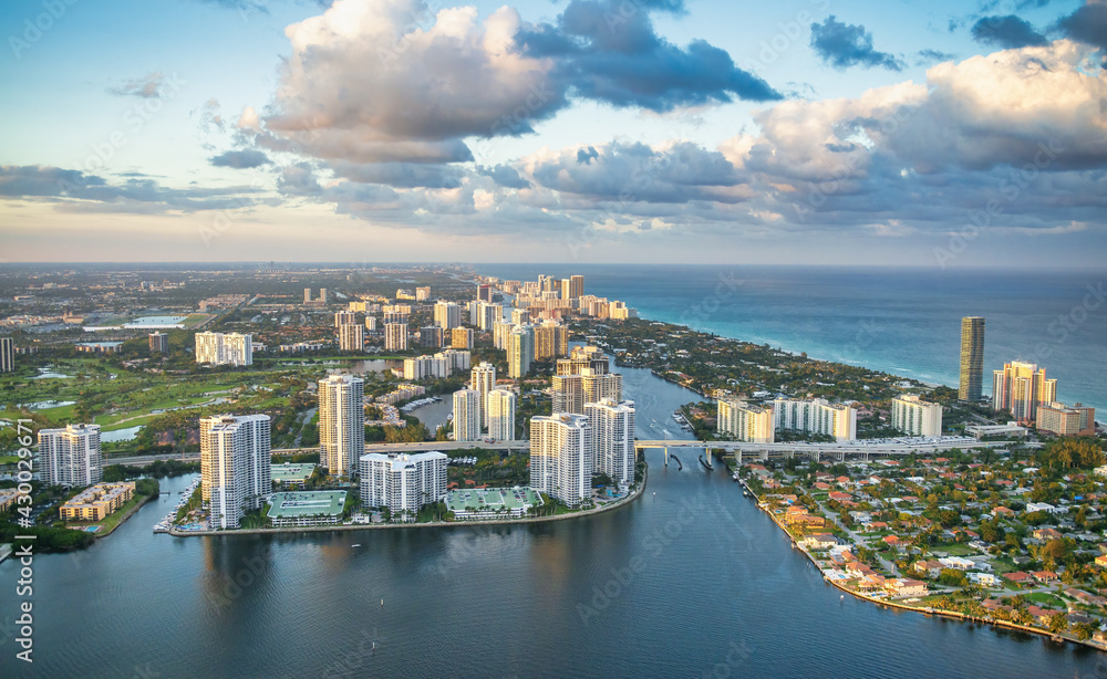 Helciopter view of Miami Beach skyscrapers along the shoreline at sunset, Florida
