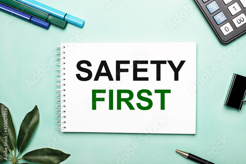 SAFETY FIRST is written on a white sheet on a blue background near the stationery and the Scheffler sheet. Call to action. Motivational concept