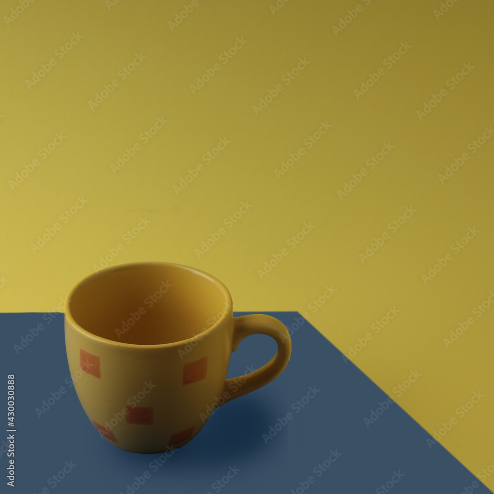Yellow cup on a blue and yellow background
Yellow cup on a blue and yellow background