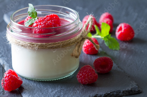 Foto Delicious dessert panna cotta with raspberry sauce, fresh raspberries and mint o