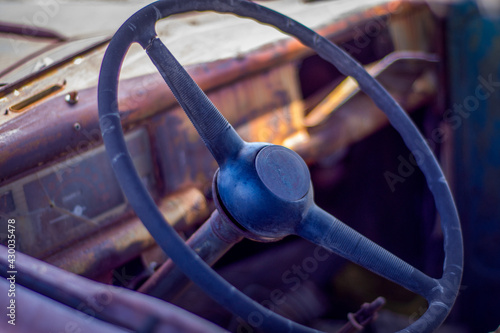 Interior view of the dash board of an old junked retro vehicle in a junkyard.