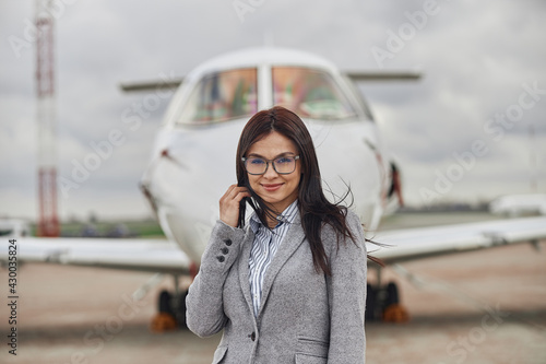 Happy female business woman near her private jet © Yaroslav Astakhov