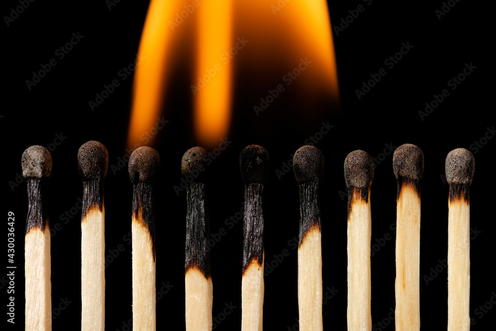 Matches on fire, black background, horizontal shot. Concept of burnout