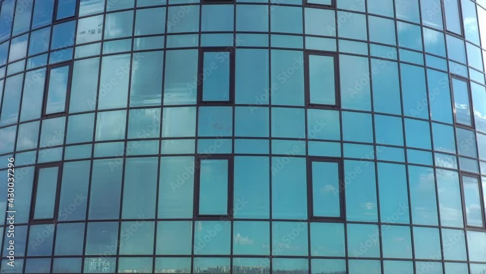 Bottom view of office building window close up, reflection and perspective. Modern architecture with sun ray. Glass facade on a bright sunny day with sunbeams on the blue sky. Bottom view of office building window close up, reflection and perspective. Modern architecture with sun ray. Glass facade on a bright sunny day with sunbeams on the blue sky.