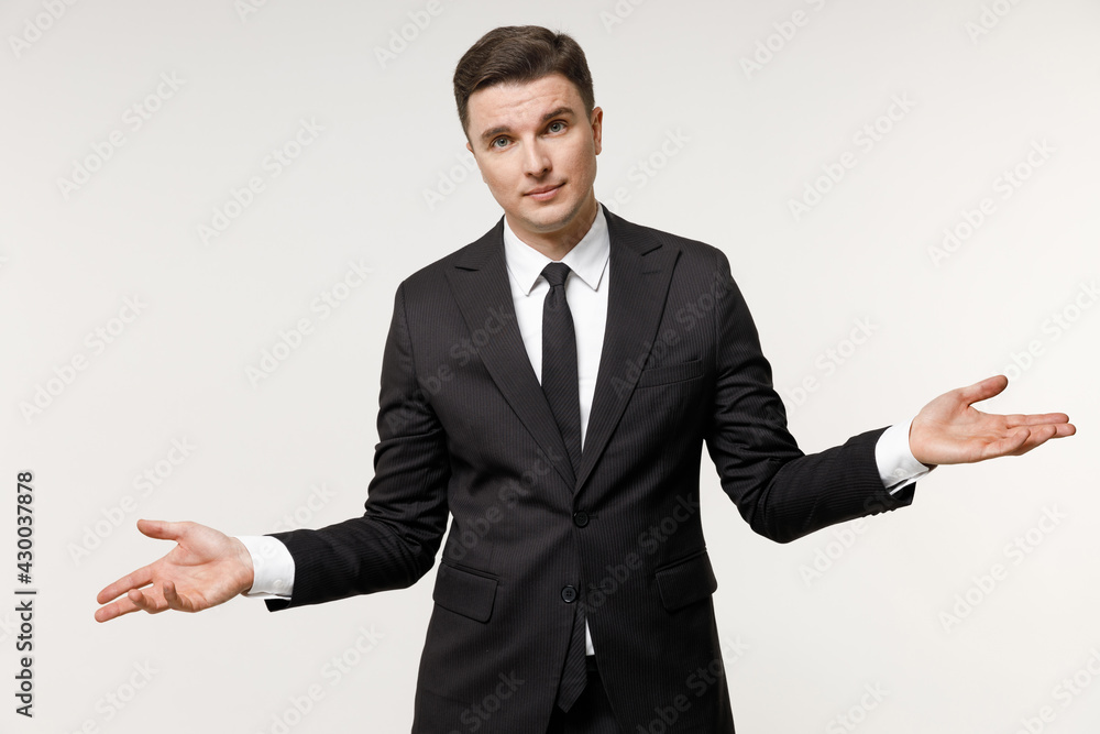 Young confused mistaken employee business corporate lawyer man 20s in classic formal black grey suit shirt tie working at office spread hands oops gesture isolated on white background studio portrait Young confused mistaken employee business corporate lawyer man 20s in classic formal black grey suit shirt tie working at office spread hands oops gesture isolated on white background studio portrait