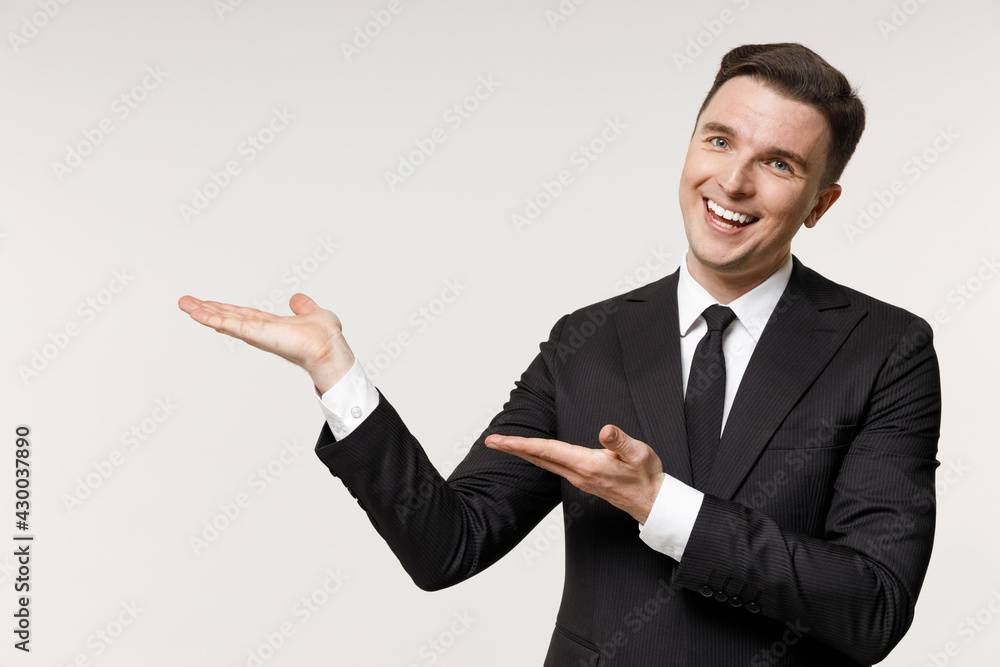 Young happy employee business corporate lawyer man wear classic formal black grey suit shirt tie work in office point index finger overhead on workspace mock up isolated on white background studio. Young happy employee business corporate lawyer man wear classic formal black grey suit shirt tie work in office point index finger overhead on workspace mock up isolated on white background studio.
