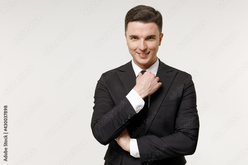 Young confident shrewd successful employee business corporate lawyer man in classic formal black grey suit shirt tie work in office corrects tuxedo tie isolated on white background studio portrait Young confident shrewd successful employee business corporate lawyer man in classic formal black grey suit shirt tie work in office corrects tuxedo tie isolated on white background studio portrait
