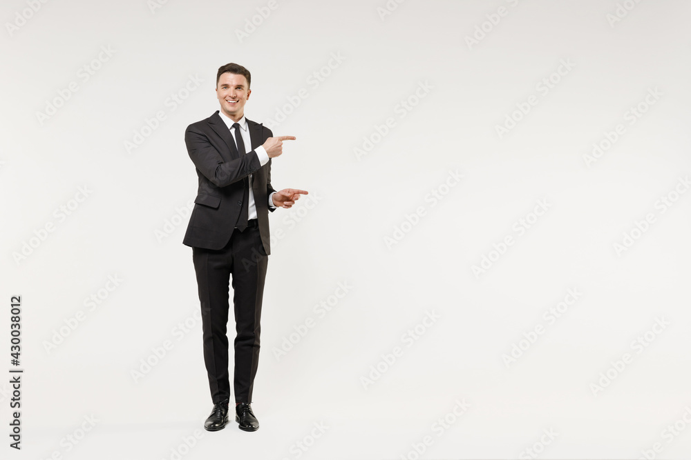 Full length young successful employee business corporate lawyer man in classic formal black grey suit shirt tie work in office point finger aside on workspace area isolated on white background studio. - obrazy, fototapety, plakaty 
