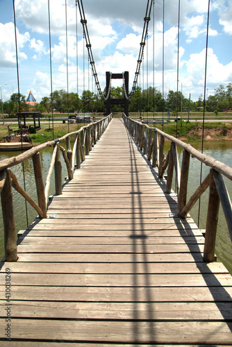 Wooden suspension bridge that crosses a reservoir in a public park in Thailand.