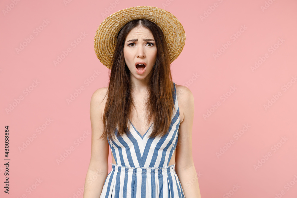 Young amazed impressed astonished caucasian woman in summer clothes striped dress straw hat looking camera with open mouth isolated on pastel pink background studio portrait. People lifestyle concept. Young amazed impressed astonished caucasian woman in summer clothes striped dress straw hat looking camera with open mouth isolated on pastel pink background studio portrait. People lifestyle concept.