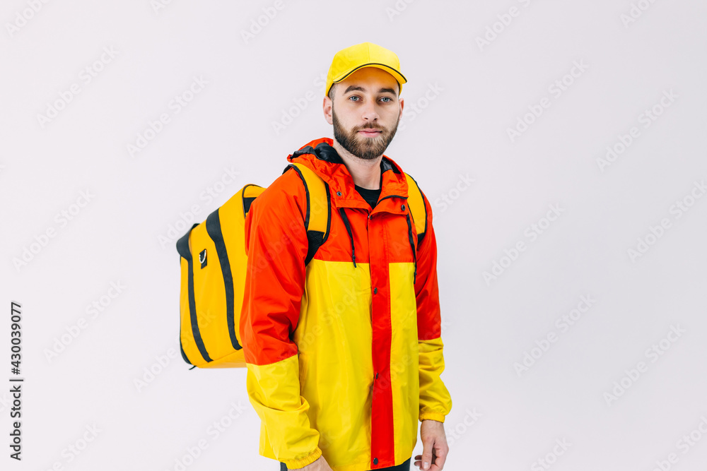 attractive delivery man in red and yellow uniform carrying backp attractive delivery man in red and yellow uniform carrying backp
