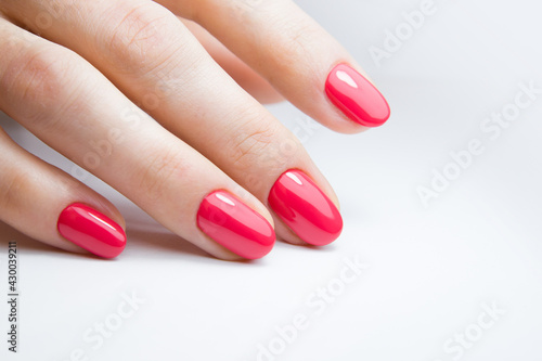 Female hand with beautiful manicure with red gel polish