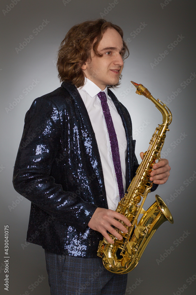 Naklejka premium Portrait of handsome stylish man holding a saxophone