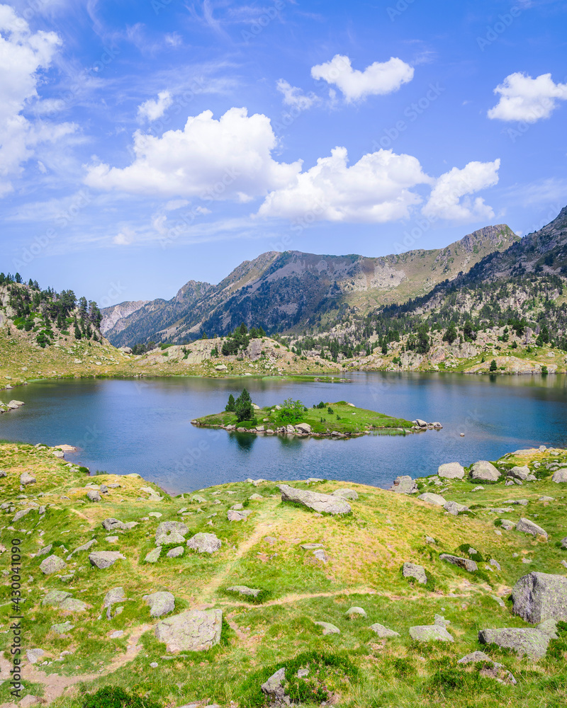 Beautiful Mountain lake surrounded by mountains with green grass on a lovely sunny summer day. Concept of mountain trip and summer vacations. Circo Saboredo, Aran Valley-Pyrenees, Catalonia, Spain. Beautiful Mountain lake surrounded by mountains with green grass on a lovely sunny summer day. Concept of mountain trip and summer vacations. Circo Saboredo, Aran Valley-Pyrenees, Catalonia, Spain.