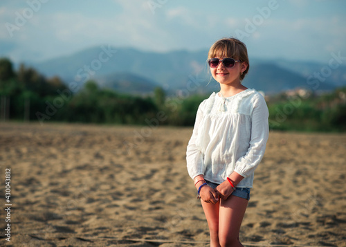 Smiling little girl in white shirt on beach vacation