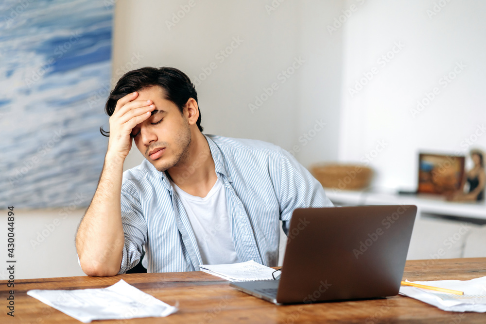 Tired jaded mixed race hispanic guy, employee, freelancer or student, in casual clothes, working or studying at laptop, experiencing stress at work, headache, need a rest, eyes closed Tired jaded mixed race hispanic guy, employee, freelancer or student, in casual clothes, working or studying at laptop, experiencing stress at work, headache, need a rest, eyes closed