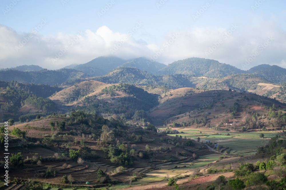 Fototapeta premium Rolling hills and farm lands with rice fields in Shan state, Myanmar