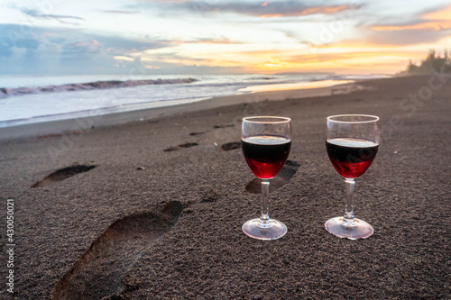 Two Wine Glasses and footprints on Hawaii Black Sand Beach honeymoon travel