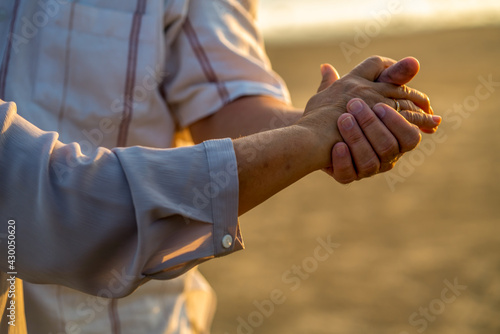 Close up elderly husband and wife holding hand together with love and trust. Healthy retirement senior couple relax and enjoy outdoor activity lifestyle. Happy Asian family on beach vacation concept.