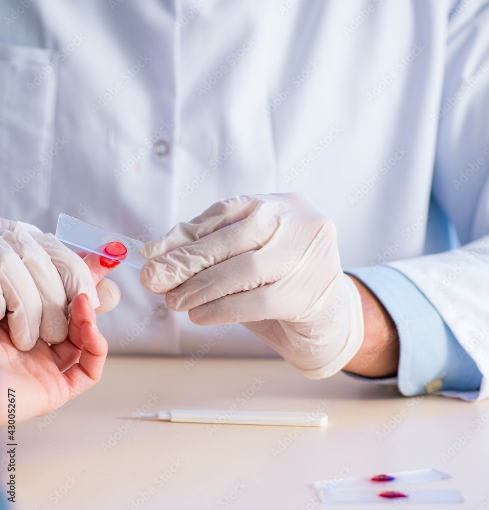 Doctor taking blood samples from finger Doctor taking blood samples from finger