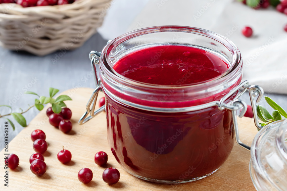 Glass jar with homemade lingonberry sauce. Canning lingonberry sauce Glass jar with homemade lingonberry sauce. Canning lingonberry sauce