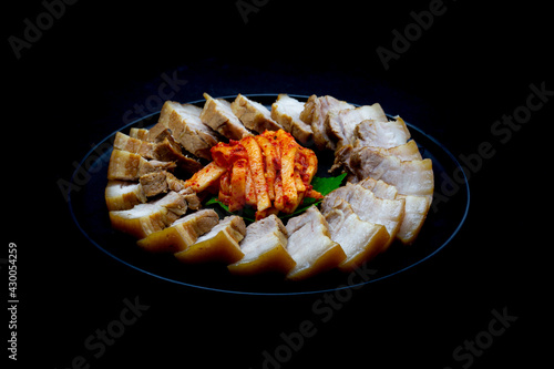 Bossam, boiled pork is eaten with spicy radish and Salted shrimp