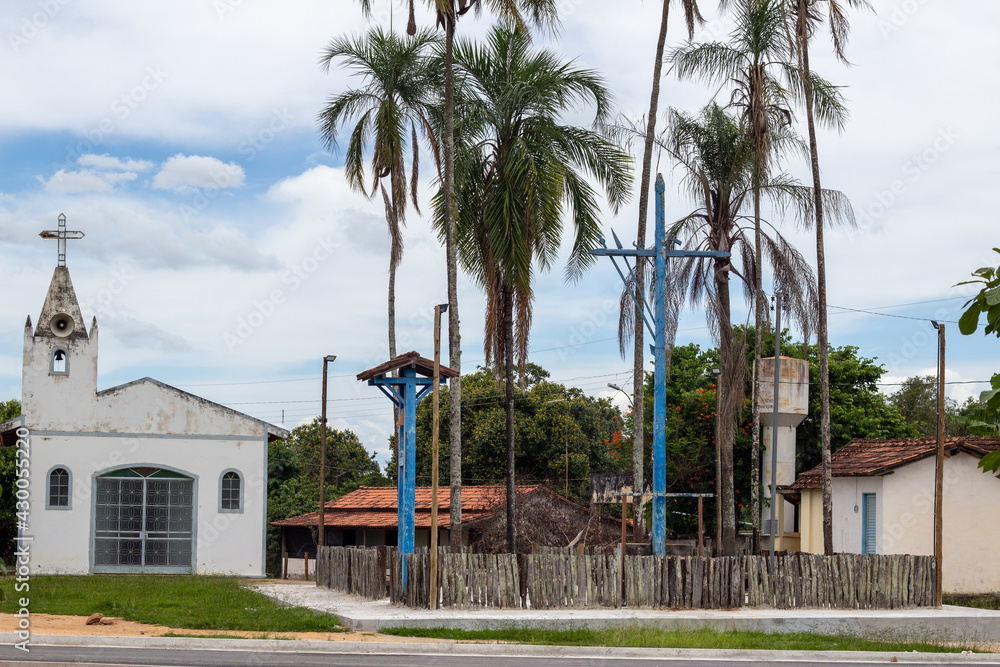 Praça de uma cidade pequena com palmeiras e uma igreja