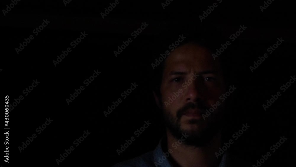 Bearded Man With Serious Facial Expression Coming Out Of The Dark. close up, studio shot Bearded Man With Serious Facial Expression Coming Out Of The Dark. close up, studio shot