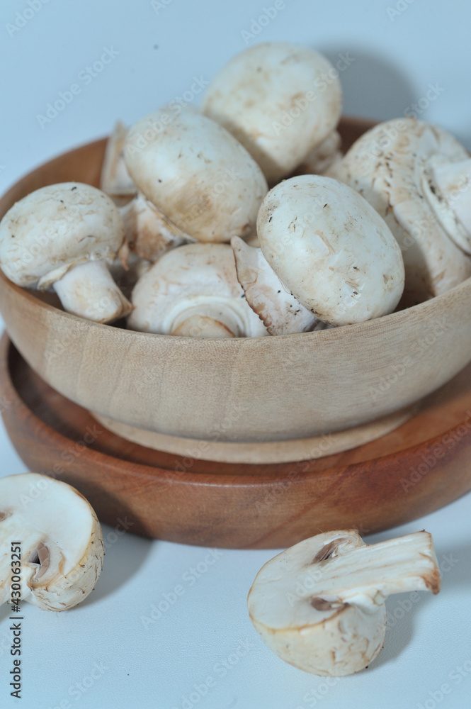 Mushrooms on a wooden chopping board on a white background Mushrooms on a wooden chopping board on a white background