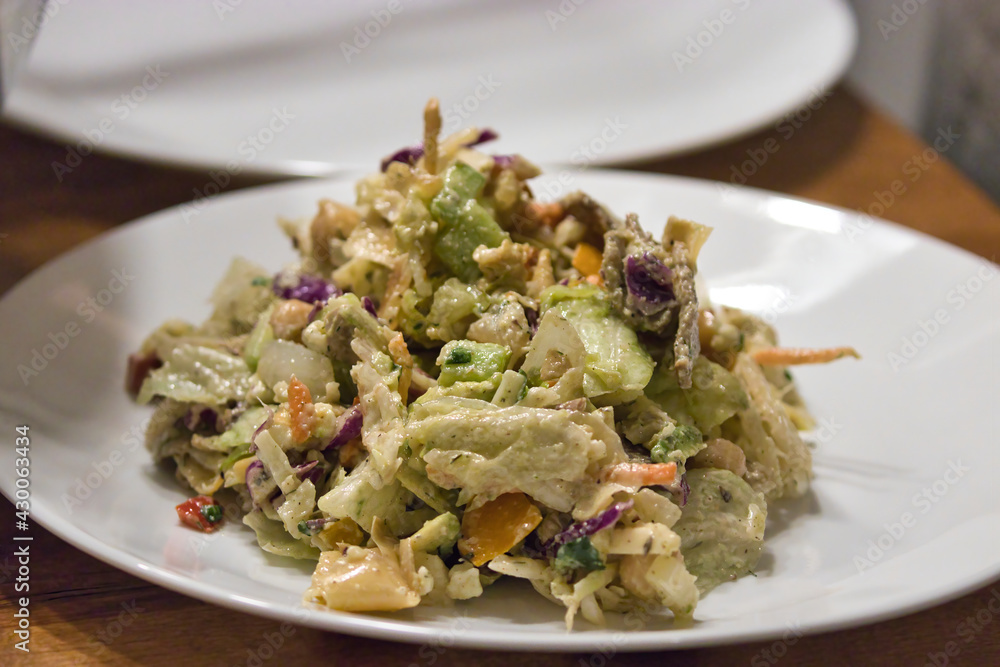 white plates holding green chopped salad with avocado dressing white plates holding green chopped salad with avocado dressing