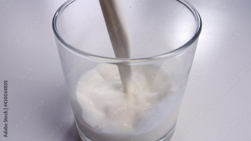 white milk is poured into a glass close-up, cinematic shot white milk is poured into a glass close-up, cinematic shot