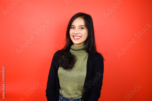 Smiling and look at camera of Young beautiful asian women using black sweater with red isolated background © Sino Images Studio