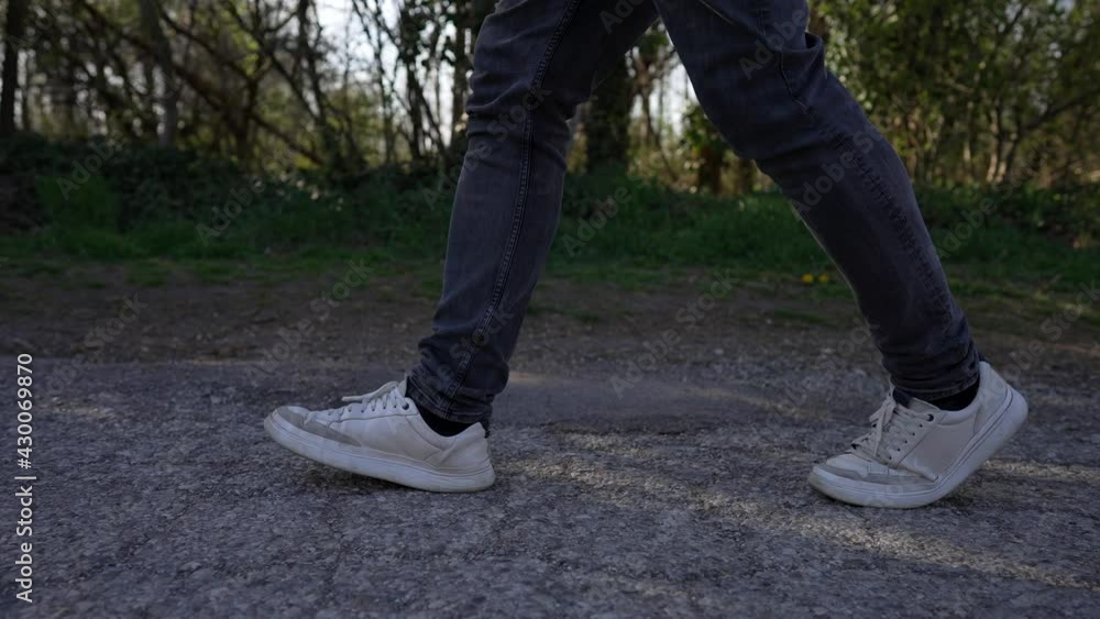 Walking on the Road, Close Up to Legs in Jeans and White Shoes, Slow Motion Walking on the Road, Close Up to Legs in Jeans and White Shoes, Slow Motion