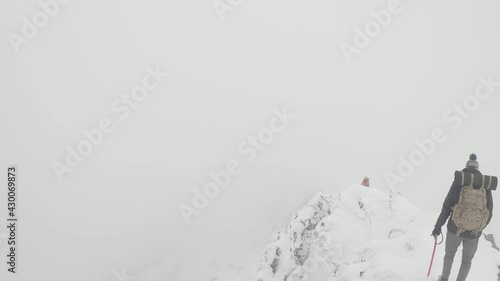 walking on snowy dangerous ridge in highest polish mountains - foggy hike in high mountains - winter hike in polish tatra mountains