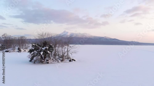 Drone flying fowrward low above beautiful frozen lake in pristine nature photo