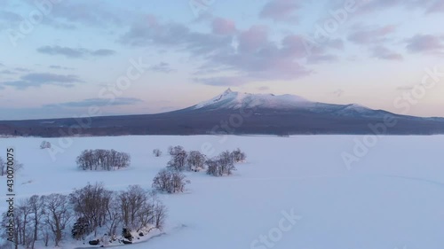 Beautiful snowed in landscape at Onuma Koen at dawn. Aerial forward shot photo