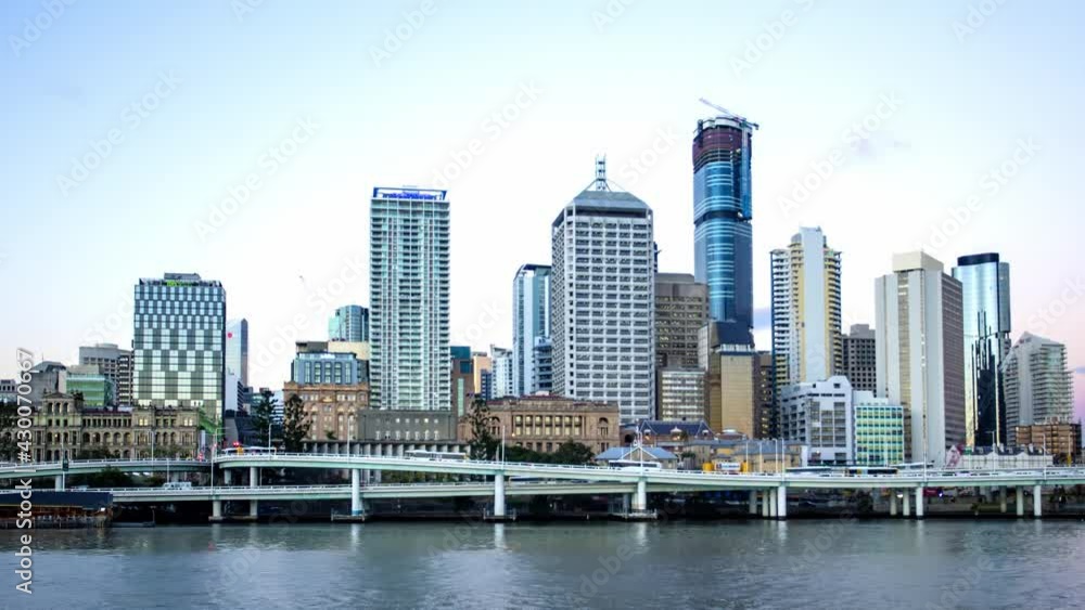 Time-lapse moving shot of a bustling city from day to night in Australia with busy vehicles and ships Time-lapse moving shot of a bustling city from day to night in Australia with busy vehicles and ships