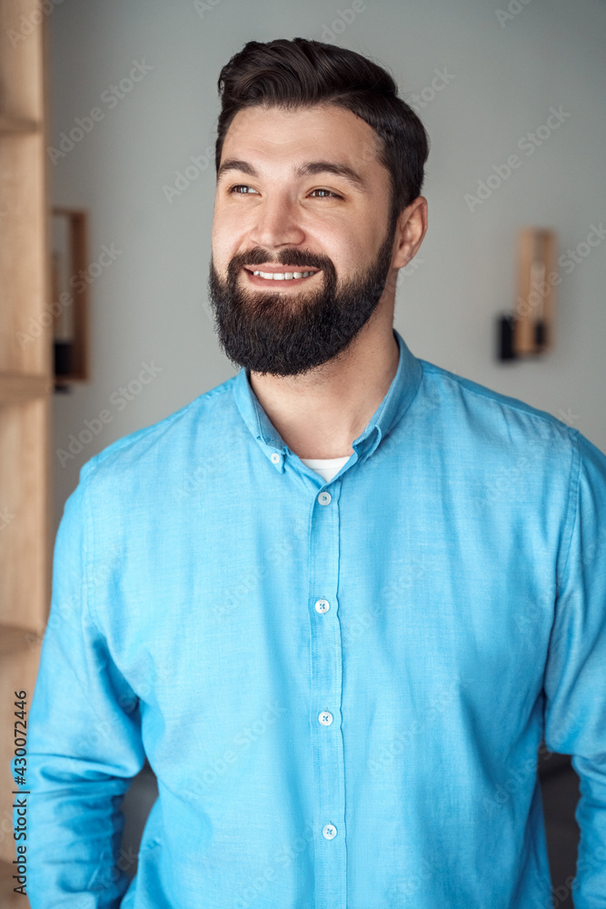Indoor headshot portrait of smiling millennial man in good mood looking aside Indoor headshot portrait of smiling millennial man in good mood looking aside